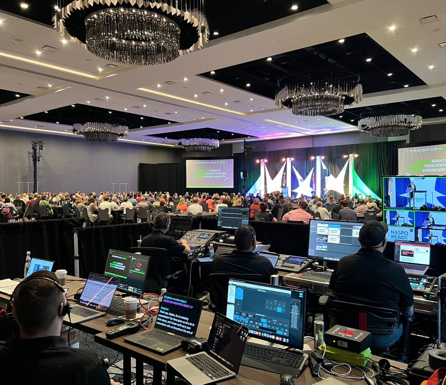 Audio, visual set up area showing techs operating equipment for a conference in a large banquet room
